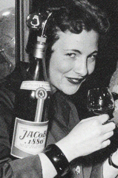 Frau im Stil der 1950er Jahre mit einer Flasche JACoBI 1880