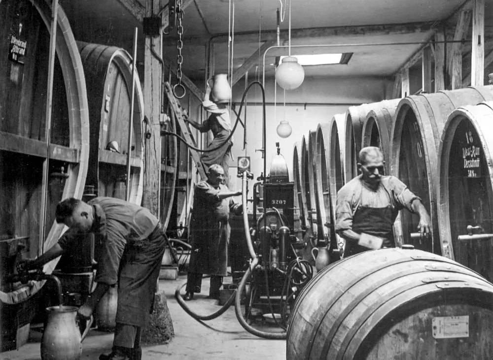 Arbeiter im Fasskeller der Weinbrennerei Jacobi, historisches Foto