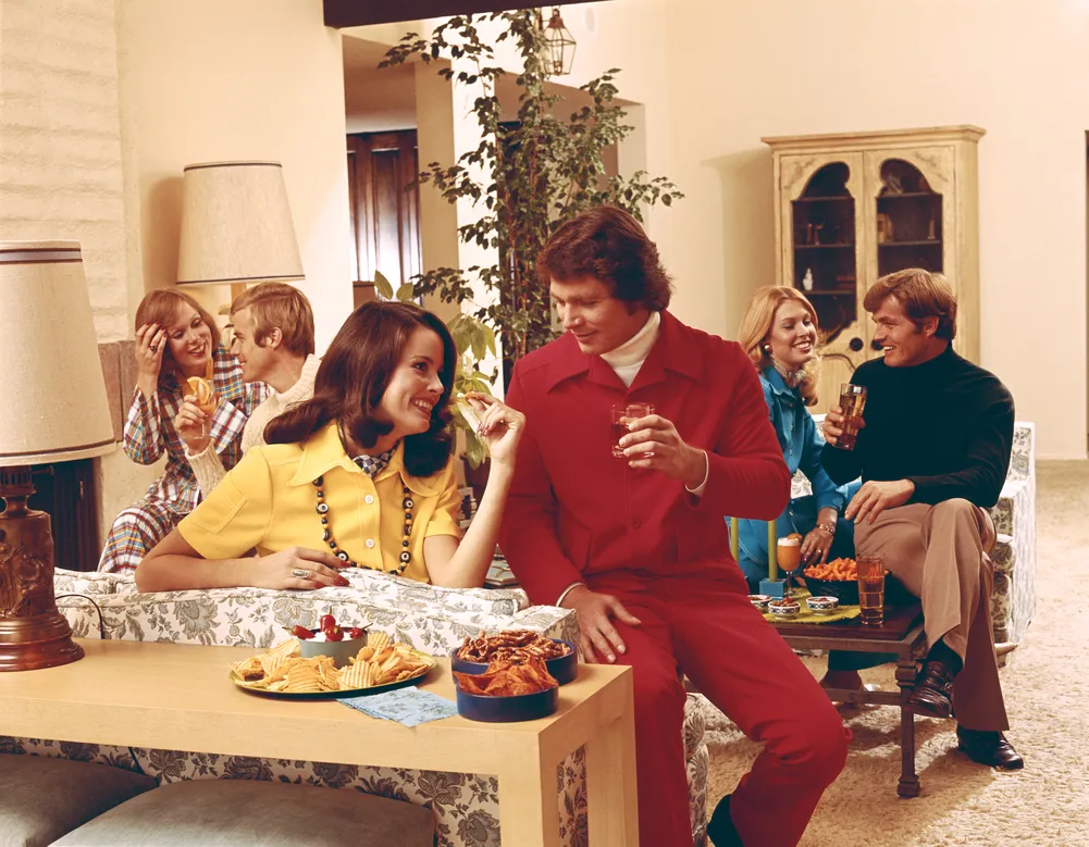Party im Stil der 1970er Jahre mit Drinks und Snacks im Wohnzimmer